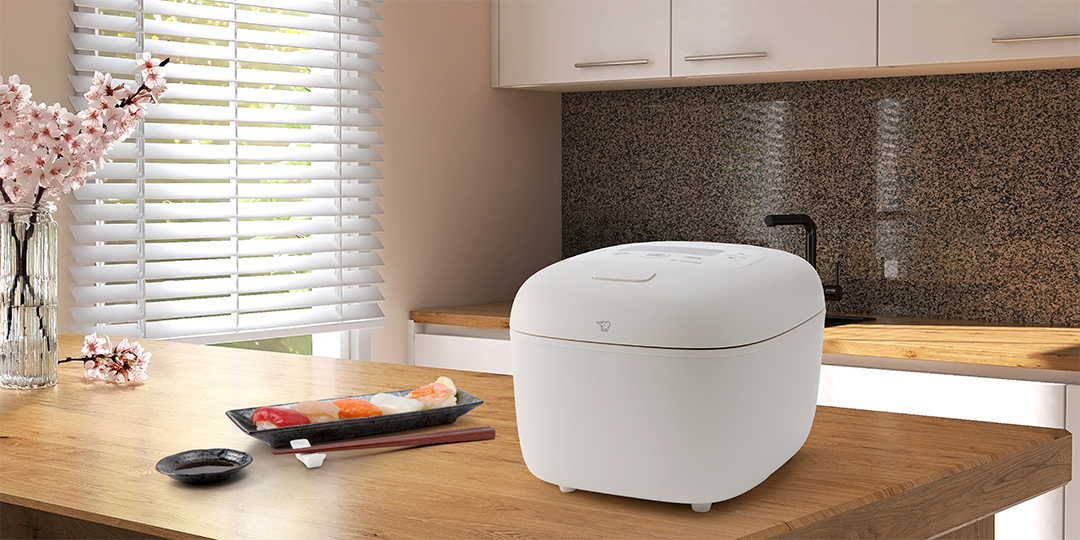 NL-EAC White Rice Cooker on a wooden countertop.