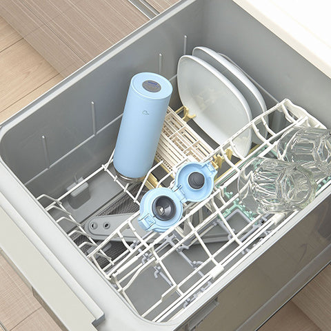 Dishwasher with dishes and a blue thermos inside