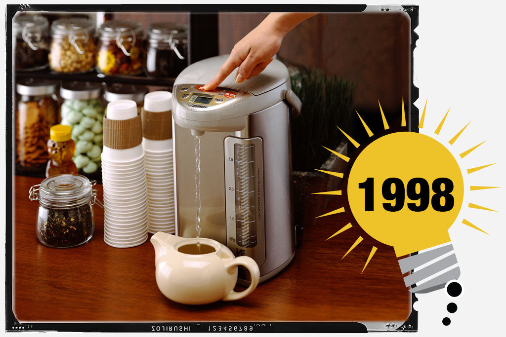 Photo of Zojirushi’s first VE® Hybrid Water Boiler & Warmer. The unit is stainless and light tan. A finger is pressing the “Dispense” button and hot water is getting poured into a tea kettle.