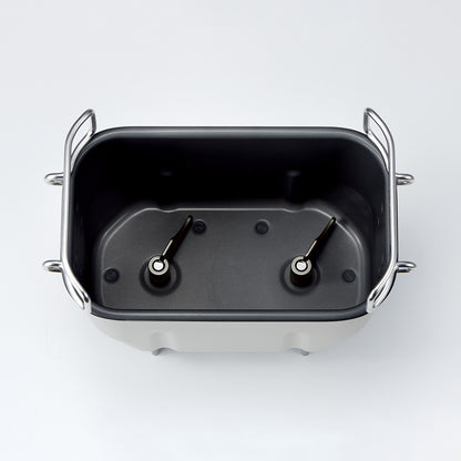 Breadmaker baking pan with metal handles on a white background