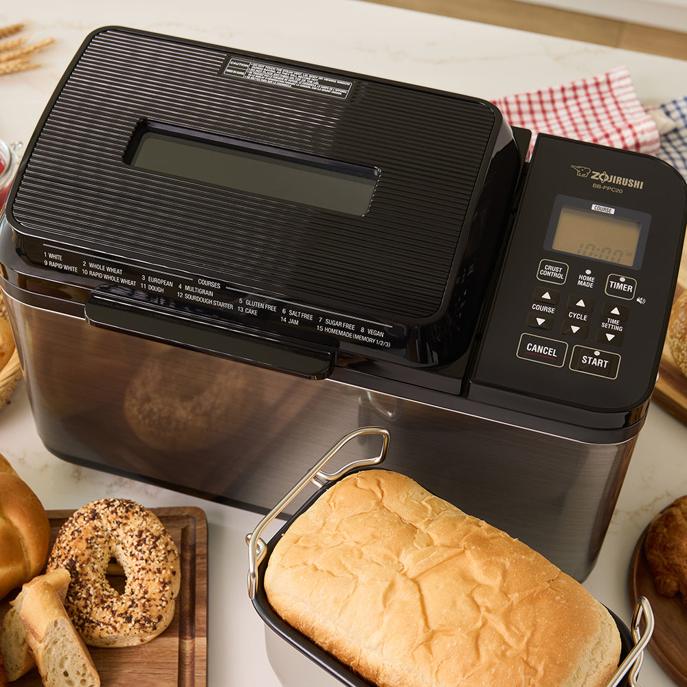 Zojirushi bread maker with loaves of bread on a table