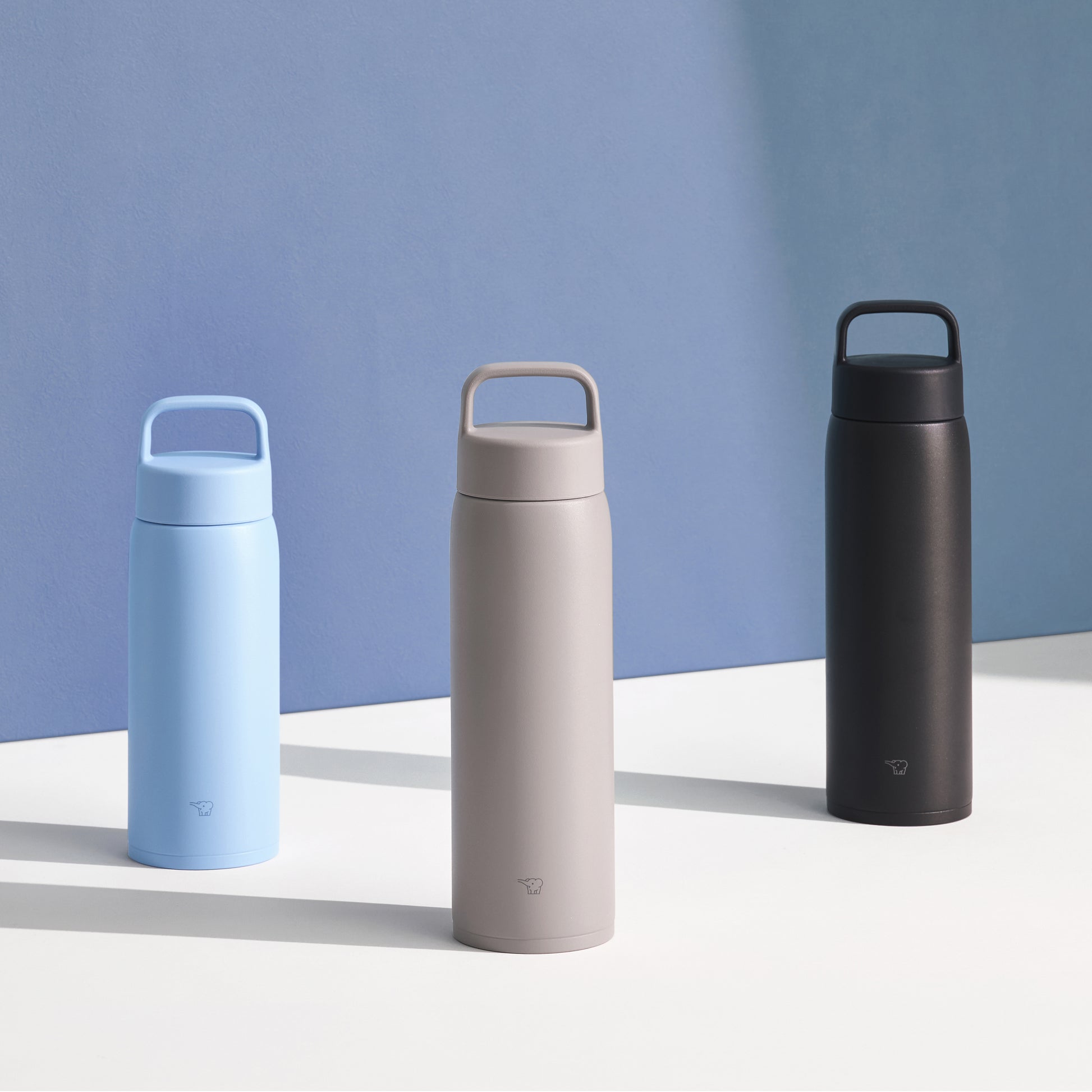 three bottles in light blue, brown beige and black