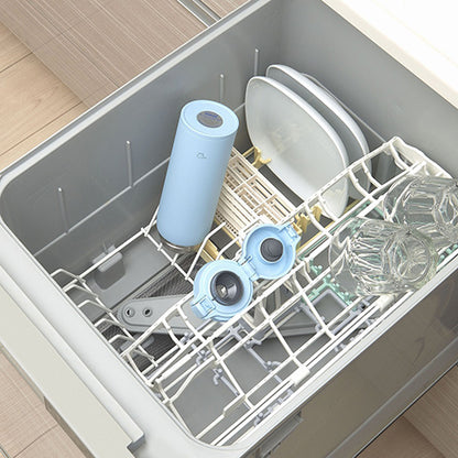 Dishwasher with dishes and a blue thermos inside